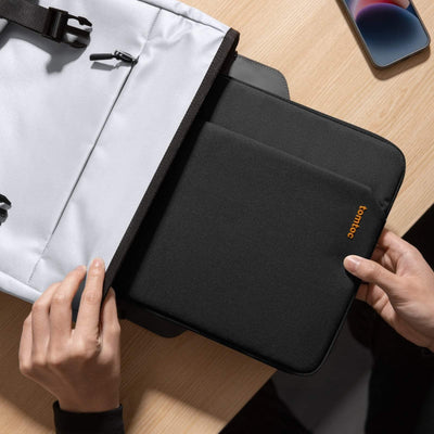 Pokrowiec na laptopa tomtoc wkładany do torby na biurku obok smartfona, akcesoria biurowe
