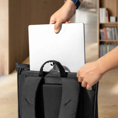 Wkładanie laptopa do czarnego plecaka, akcesoria do biura, home office
