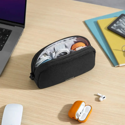 Etui na akcesoria biurowe i kable na biurku obok laptopa i słuchawek bezprzewodowych
