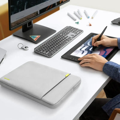 Nowoczesne biurko z klawiaturą, monitorem, tabletem graficznym i szarą torbą na laptopa