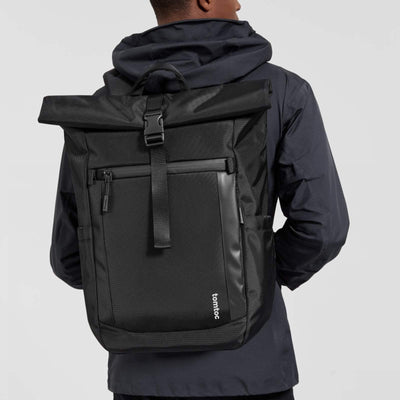 Czarny plecak na laptopa typu rolltop, mężczyzna w kurtce, nowoczesny design