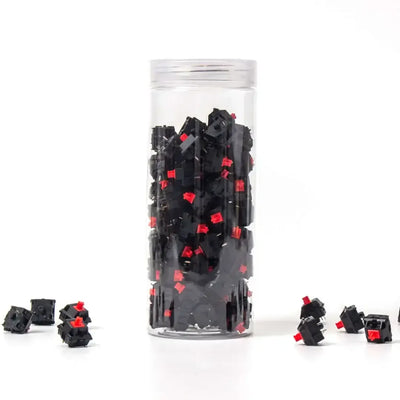 Zestaw czerwonych switchy do klawiatury mechanicznej w przezroczystym pojemniku.