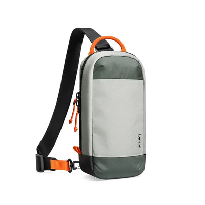 Nowoczesna torba na ramię typu sling, szara z zielonymi i pomarańczowymi akcentami.