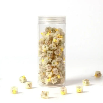 Przełączniki mechaniczne Gateron Cap V2 Milky Yellow w przezroczystym pojemniku na białym tle