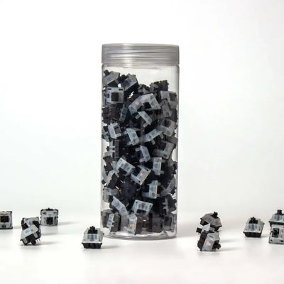 Przełączniki mechaniczne Gateron KS-3X47 Milky Black w przezroczystym pojemniku na białym tle