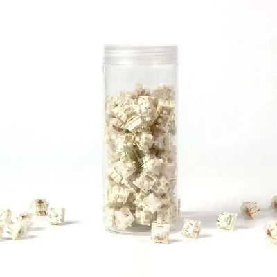 Białe przełączniki mechaniczne do klawiatur w przezroczystym pojemniku na białym tle