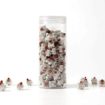 Zestaw switchy Kailh Speed Bronze do klawiatur mechanicznych w przezroczystym pojemniku.