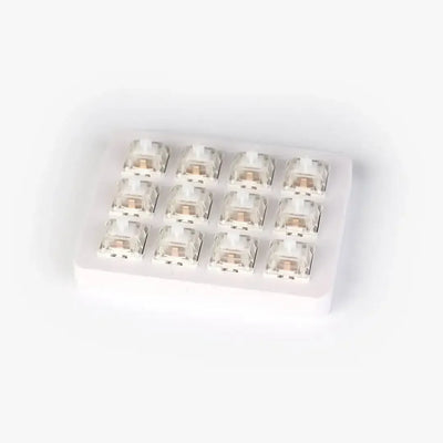 Białe switche mechaniczne w przezroczystej obudowie na stojaku, akcesoria do klawiatury.