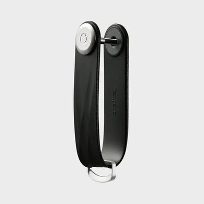 Czarny organizer na klucze, minimalistyczny akcesorium do biura, widok na szarym tle