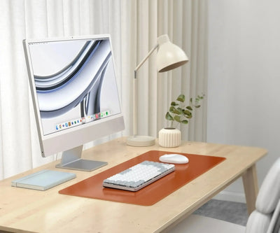 Biurko z matą z wegańskiej skóry, klawiaturą mechaniczną, myszką i monitorem w nowoczesnym home office